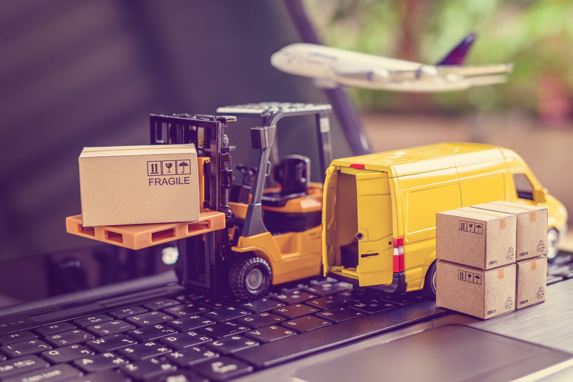 Concepto de logística, cadena de suministro y servicio de entrega: El montacargas mueve un palet con cartón para cajas. Van en un ordenador portátil, representa una amplia gama de productos en todo el mundo en la era popular del comercio electrónico